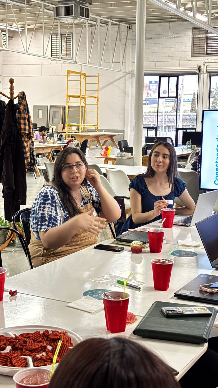Dos asistentes platicando en el Code & Wine